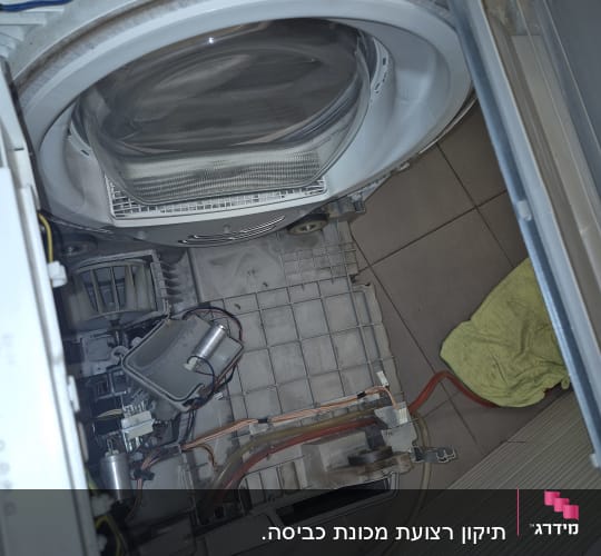 מכונת כביסה פתוחה עם חוטים ורכיבים חשמליים